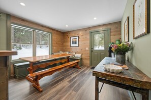 A cozy room with a wooden bench, a table, and a door.
