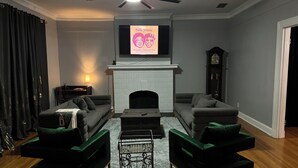 A living room with a fireplace, two sofas, a coffee table, and a ceiling fan.