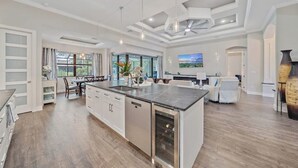 Une cuisine spacieuse dotée d’un îlot central, d’appareils électroménagers intégrés et d’un coin repas offrant une vue agréable.