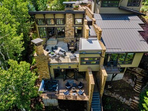 Une maison moderne dotée d’un patio, d’un espace salon extérieur et d’un jacuzzi.