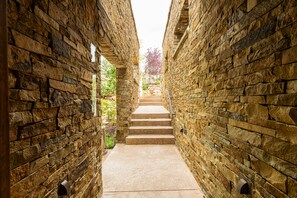 A stone corridor with a staircase leading to a higher level.