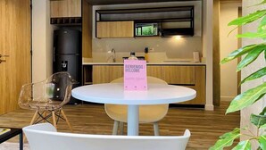Una cocina moderna con una mesa de comedor redonda, una silla transparente y un cartel de bienvenida.