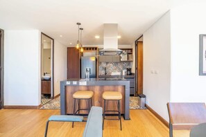 A modern kitchen with a central island, bar stools, and a dining area with a bench. - NOK Stylish 2 Masters w/Patio & View (Bogotá)