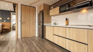 Cozinha moderna com armários de madeira, geladeira de aço inoxidável e micro-ondas.