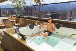 Relax in style on the rooftop terrace, where a hot tub and wicker seating area offer breathtaking city and mountain views.