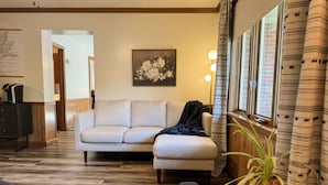 Een woonkamer met een bank, een salontafel en een bloempot.