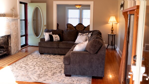 A living room with a gray sofa, patterned rug, and a fireplace.
