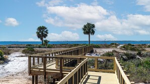 A wooden boardwalk leading to a beach with palm trees and a clear blue sky. - 5BR WindMark Beach Bunk Room, Pools, Golf Cart, Ping Pong  (Port St. Joe)
