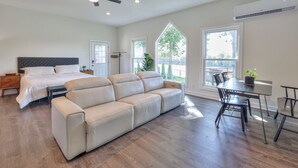 Une chambre spacieuse avec un grand lit, un canapé et un coin repas comprenant des chaises et une table.