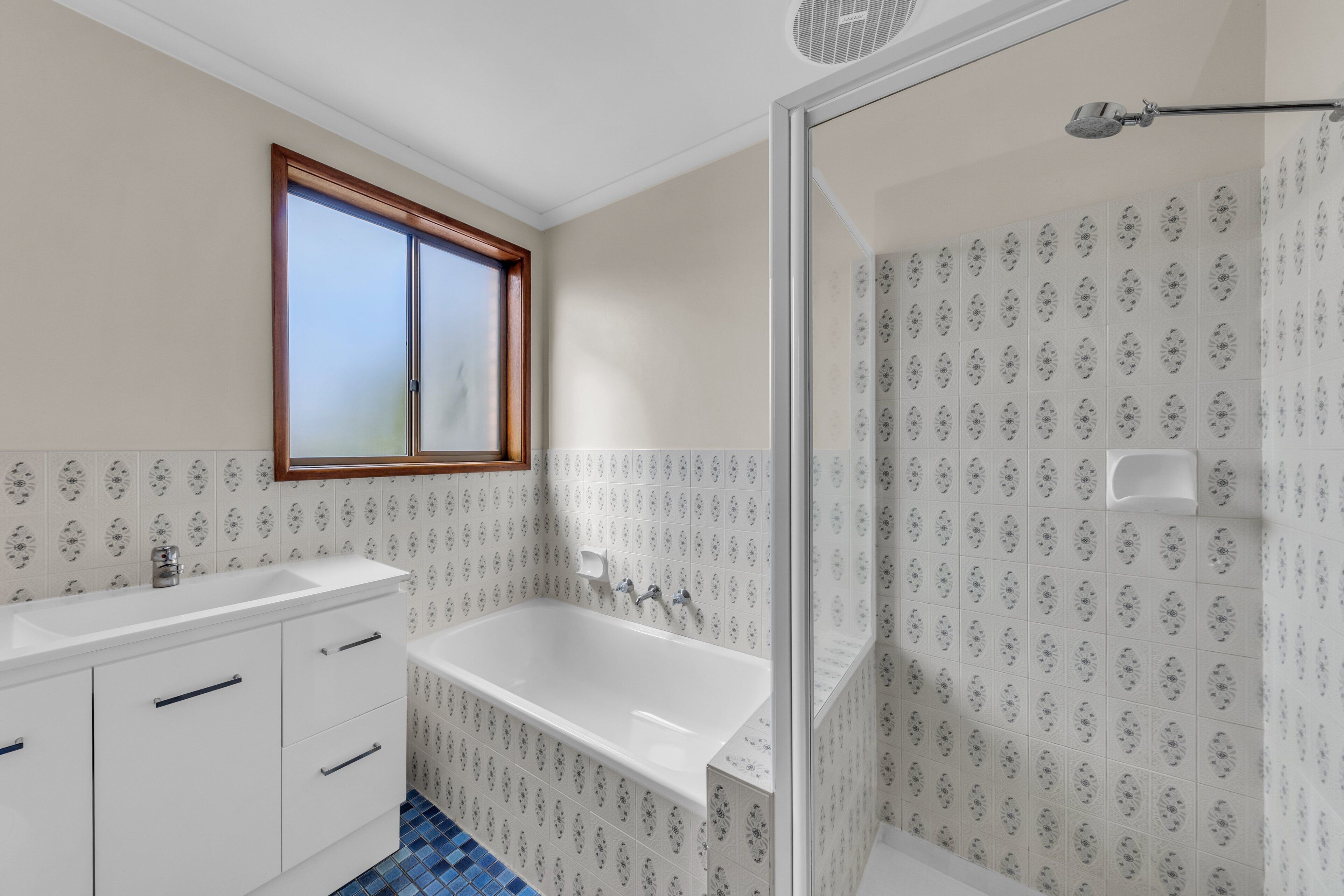 A bathroom with a white sink, a bathtub, and a shower.
