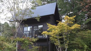 A two-story building with a dark exterior and a sloped roof. - KAMATA SANSO (Hakuba)