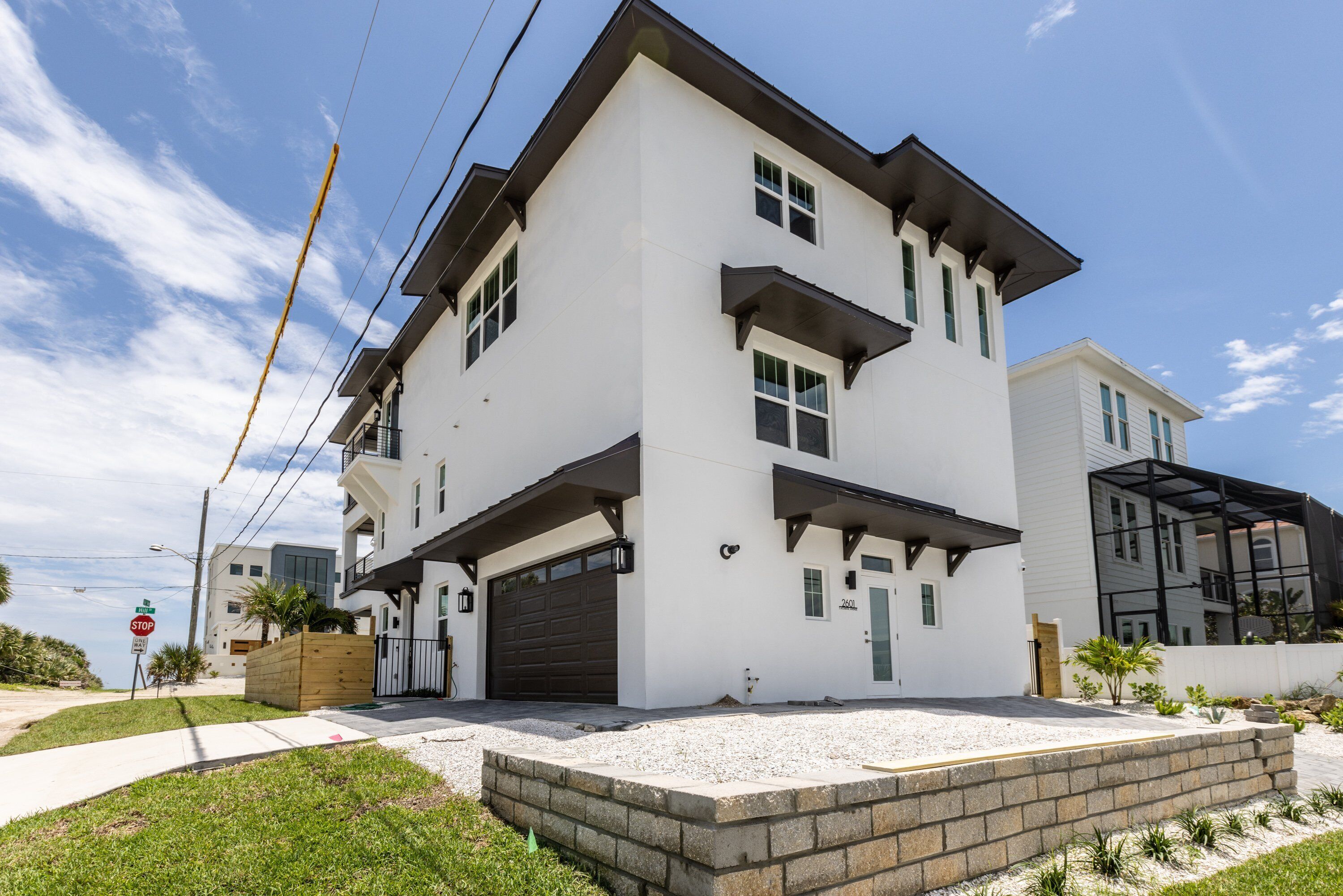 A modern two-story house with a garage, a covered driveway, and a landscaped front yard.