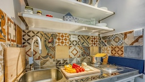Une cuisine équipée d’un évier, d’une planche à découper avec des légumes et d’une cuisinière.