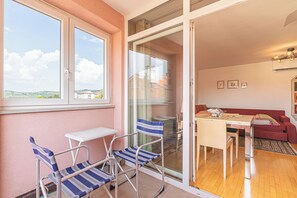 Enjoy a cozy living space with a balcony offering a view of the surrounding landscape.