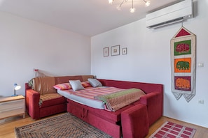Restful retreat with a sofa bed, bedside table, and lamp, perfect for a straightforward stay.