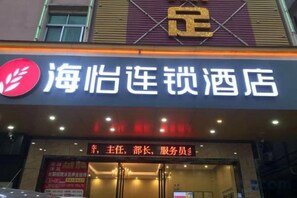 Ein Hotelschild mit chinesischen Schriftzeichen und einem roten Logo.