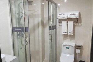 Une salle de bain avec une douche à parois de verre, des toilettes et deux serviettes suspendues sur un porte-serviettes.