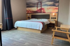 A hotel room with a bed, a nightstand, a desk, a chair, and a wall mural of a bridge. - Dongguan Haiyi Chain Hotel (Dongguan)