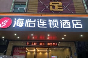 Un letrero de hotel con caracteres chinos y un logotipo rojo.