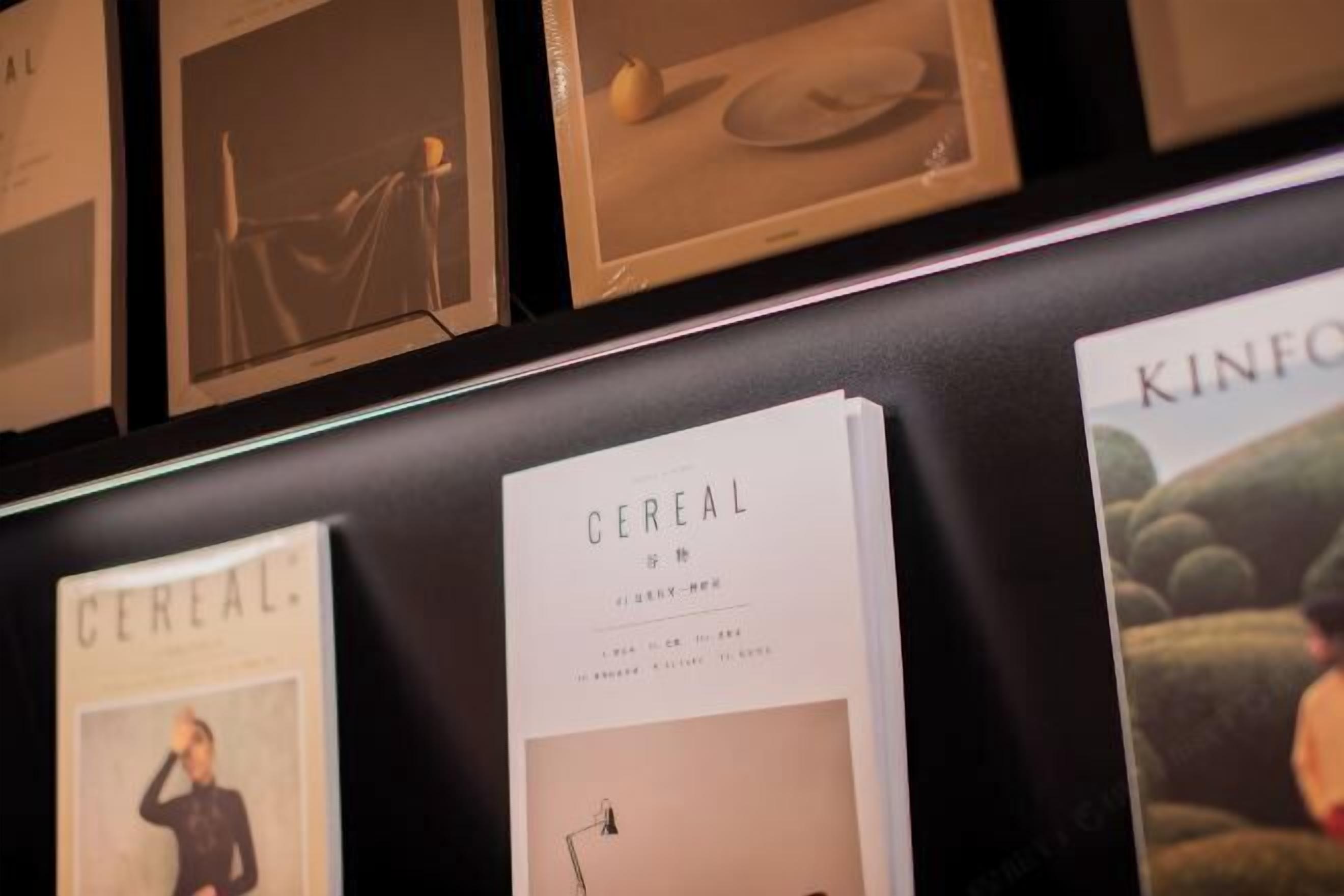 Eine Wand mit gerahmten Bildern und einem Buch mit dem Titel 'Cereal'.