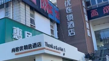 A building with multiple signs, including one for a hotel and another for a store.
