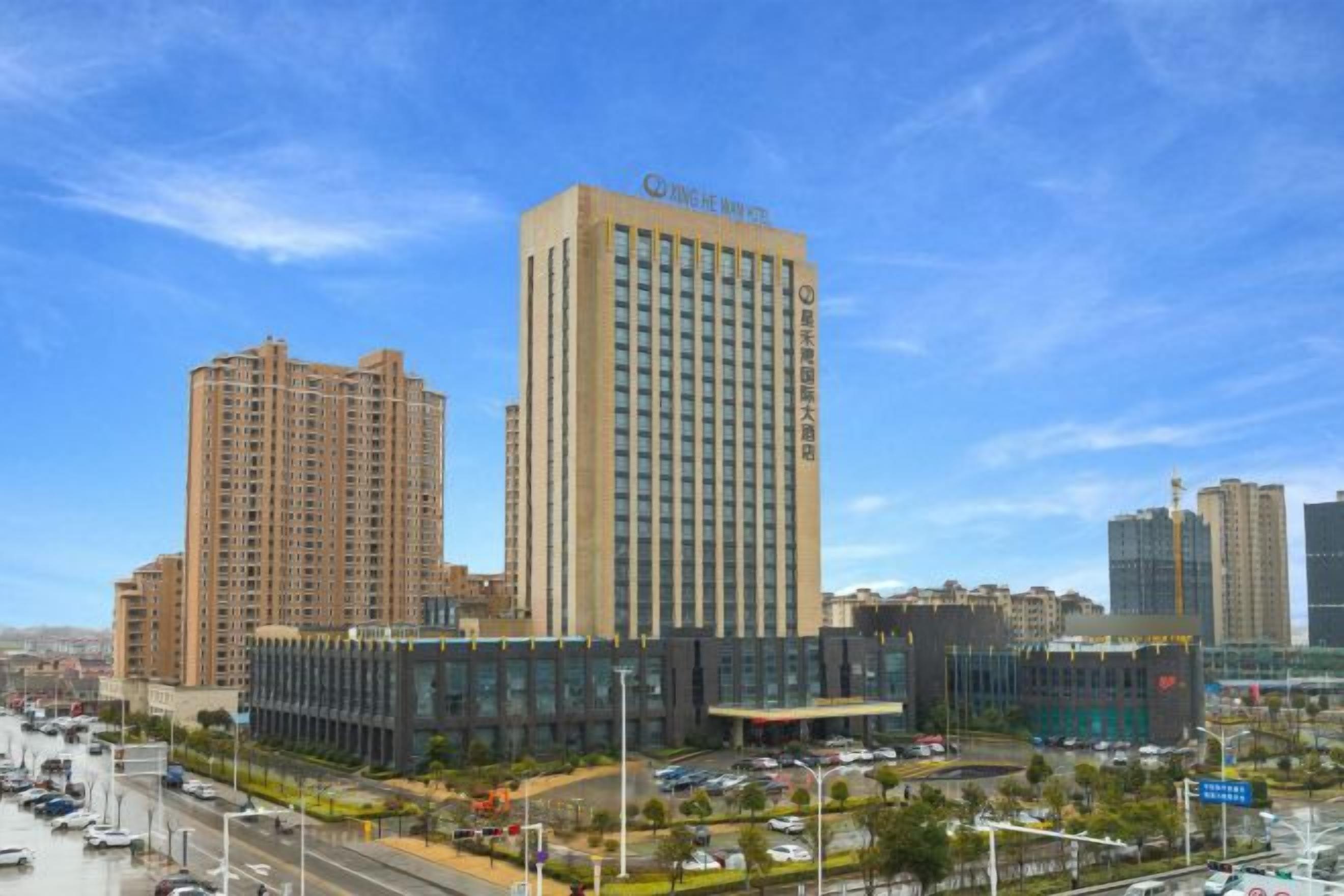 A high-rise hotel with multiple floors, a modern design, and a parking area in front.