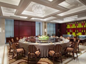 A conference room with a round table, chairs, and a chandelier. - Xinghewan International Hotel (Sheyang)