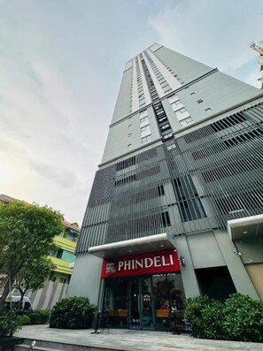 A tall building with a PHINDELL sign at the ground level. - Urban Zen Saigon - SOHO Residence D1 (Ho Chi Minh City)