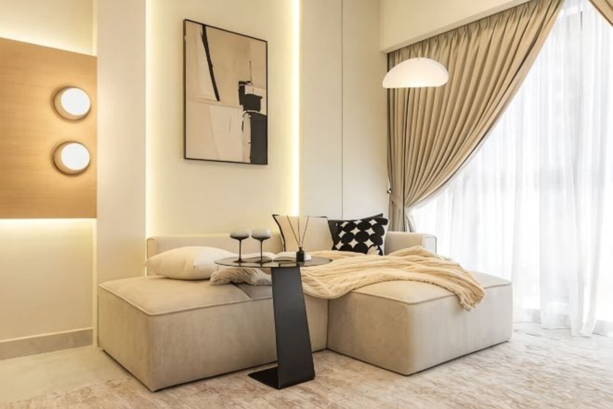 A modern living room with a sofa, a coffee table, a lamp, and a painting on the wall.