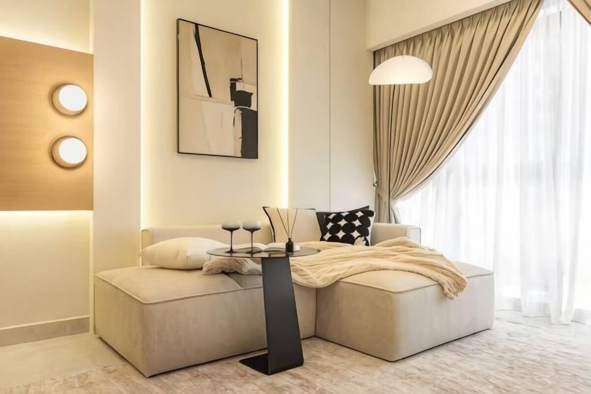 A modern living room with a sofa, a coffee table, a lamp, and a painting on the wall.