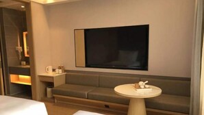 A modern hotel room with a sofa, a small round table, and a large mirror. - JI Hotel (Beijing Shangdi Anningzhuang) (Beijing)