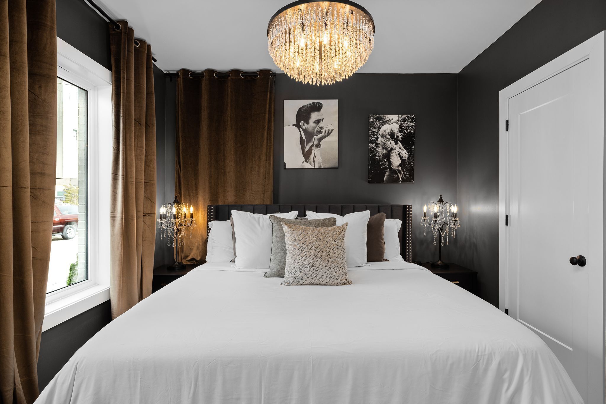 Ein Schlafzimmer mit einem großen Bett, einer Kandelaber und Kunstwerken an der Wand.