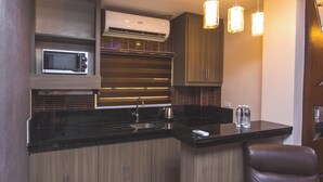 Una cocina moderna con microondas integrado, pileta de acero inoxidable y luces colgantes.