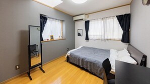 A compact hotel room with a bed, a desk, a chair, a mirror, and a window with curtains. - NOT A HOME Kameari Station 5 min. walk Free parking Disney Haneda Airport bus direct 90m2 Tea ceremony experience (葛飾区)