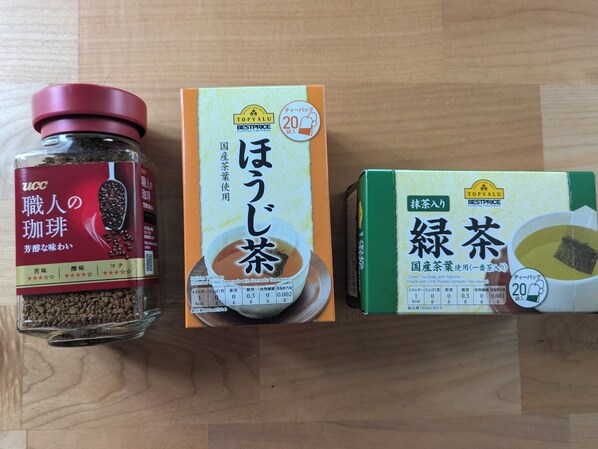 Tres cajas de productos de té japonés sobre una superficie de madera.