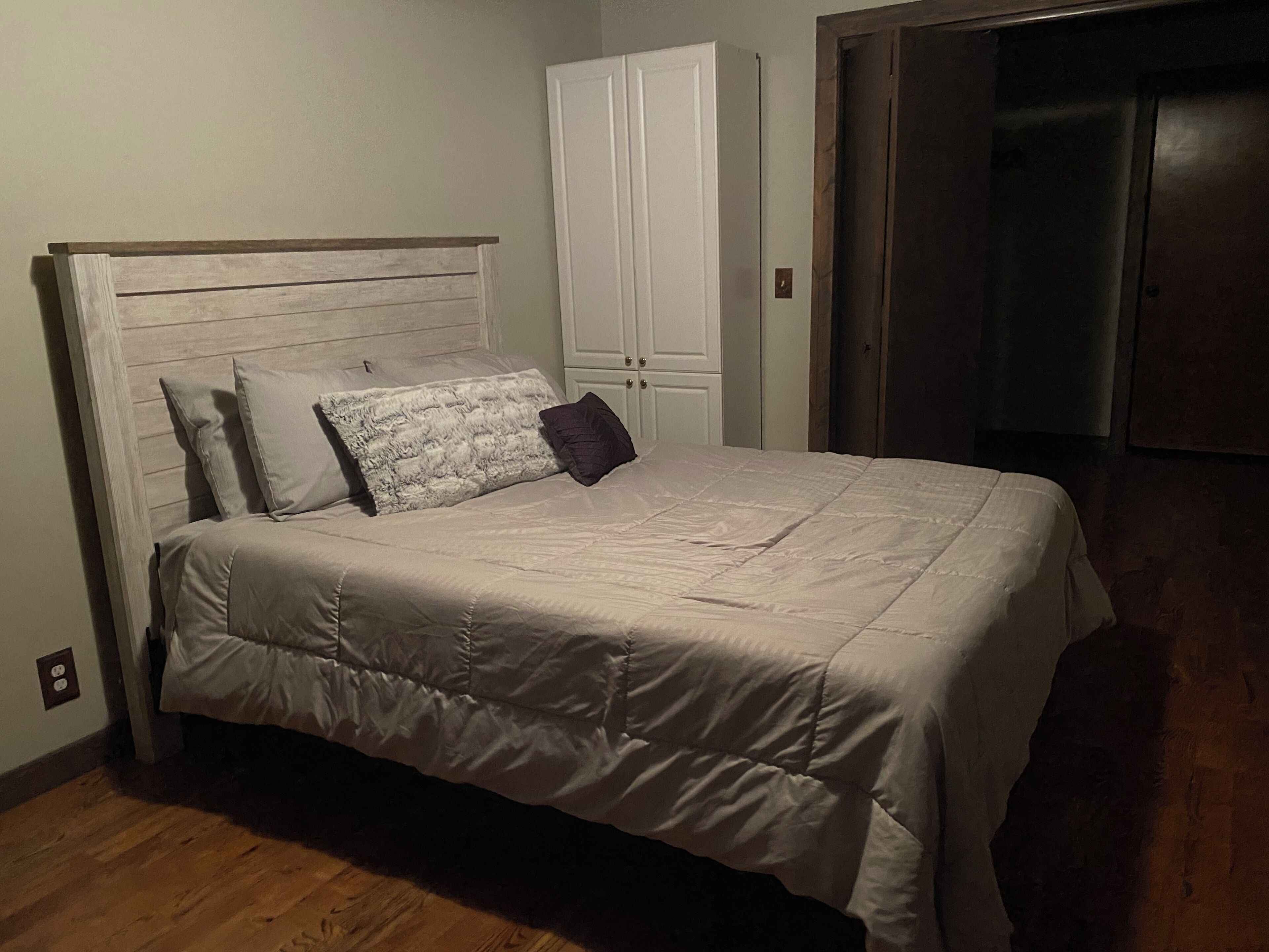 Un dormitorio con cama, armario y puerta.