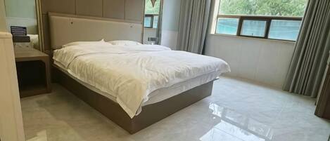 Une chambre à coucher avec un lit, une table de chevet et une fenêtre avec des rideaux.