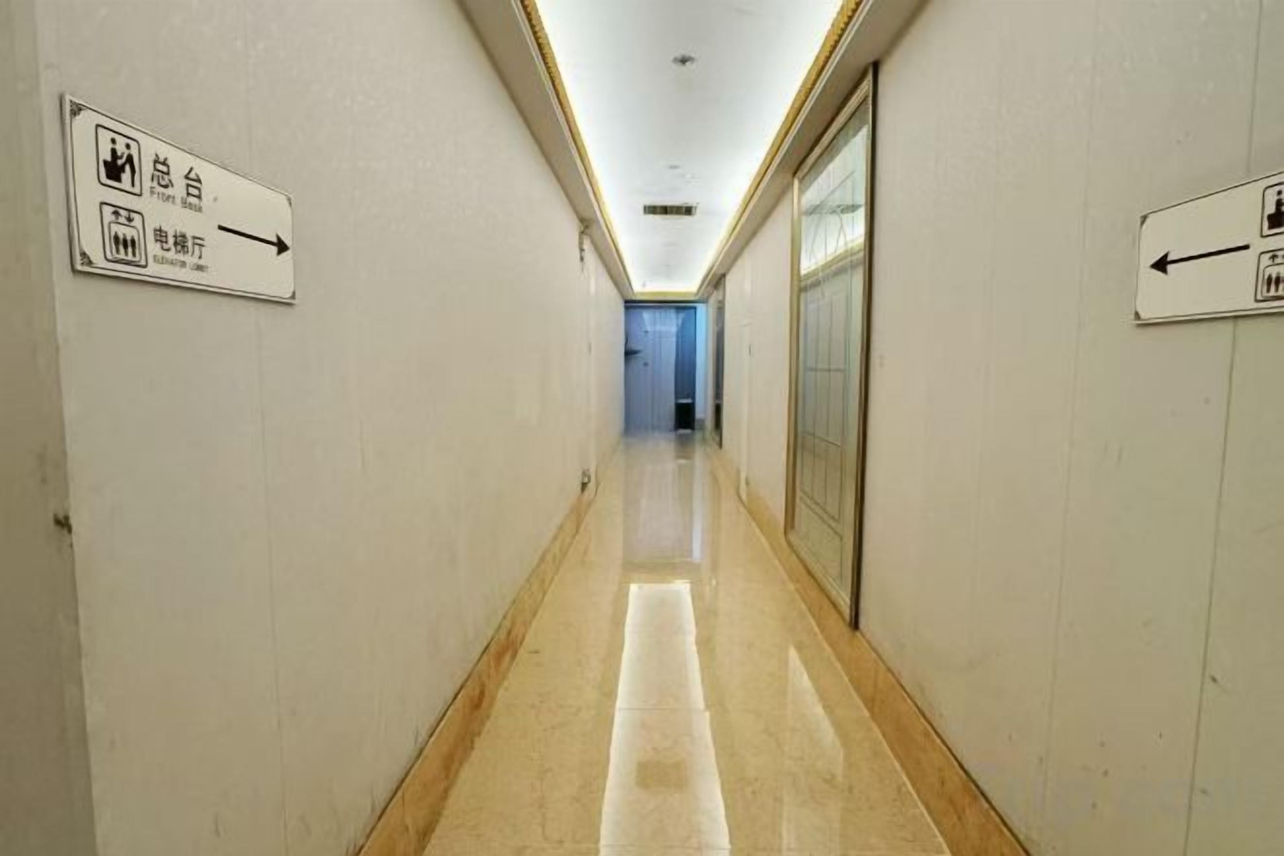 A corridor with directional signs indicating facilities like restrooms and a lift.