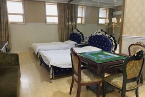 Een hotelkamer met twee bedden, een bureau met een groen viltkleed en een stoel.