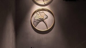 A wall with a circular decorative piece and a rock. - MILA HOTEL (Shanghai)