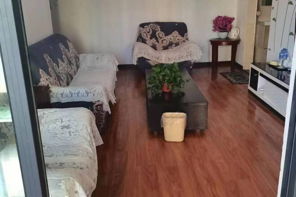 Un salon comprenant un canapé, une table basse, une table d’appoint avec une plante et un meuble.