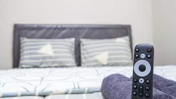 Un lit avec une télécommande posée dessus.