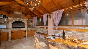 Una cocina rústica con un horno de ladrillo, armarios de madera y encimera de piedra.