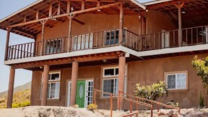 A two-story building with a balcony and a green door.