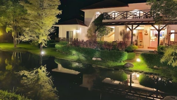 A modern house with a well-maintained garden and a pond. - Bali Hostel (Hualien)