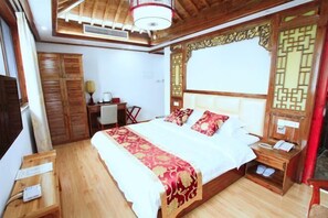Ein Schlafzimmer mit einem hölzernen Bett, einem Schreibtisch, einem Stuhl und einem Kleiderschrank.