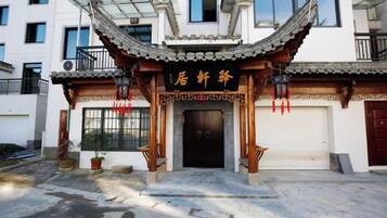 A traditional Chinese building with a tiled roof and a black entrance door.