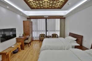 A hotel room with a bed, desk, TV, and a view of the outdoors. - Yi Xuan Ju Deluxe Lnn and Suites (Yi County)