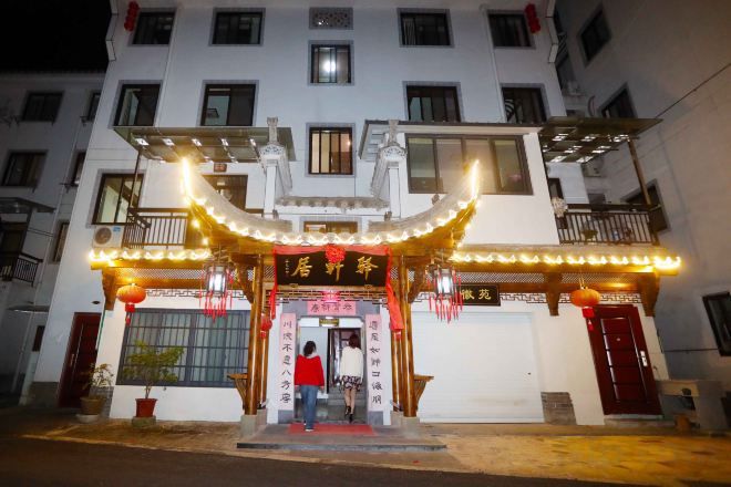 Un edificio con una entrada de arquitectura tradicional china, que presenta un arco rojo y luces decorativas.