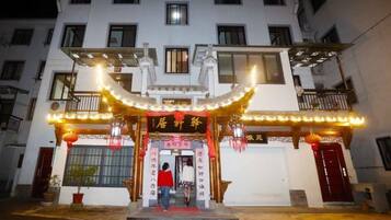 A building with a traditional Chinese architectural entrance, featuring a red archway and decorative lights.